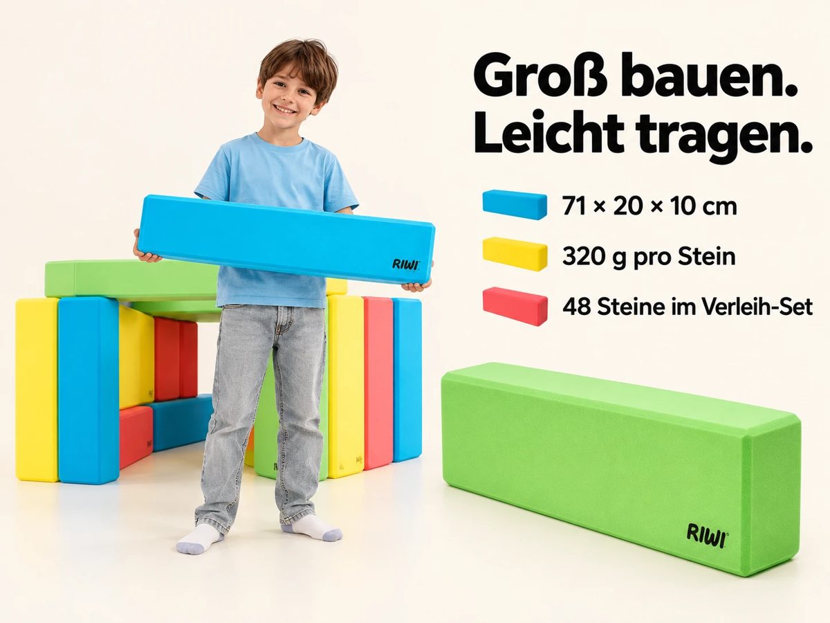 Ein Junge trägt einen großen blauen Baustein, dahinter steht eine Hütte aus bunten Steinen